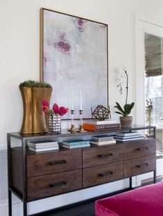 a living room with a large painting on the wall next to a purple couch and coffee table