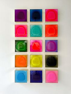 several different colored squares are arranged on the wall