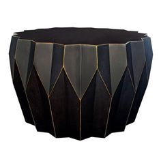 a black and gold side table with geometric shapes on the top, in front of a white background