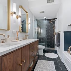 a bathroom with black and white tile flooring and gold accents on the vanity mirror