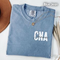 a blue shirt with the word ona written in cursive writing next to a cowboy hat