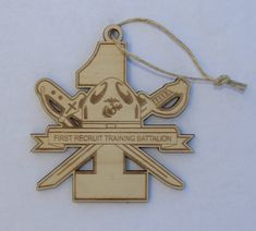 a wooden ornament with the words first recruit training station hanging from a cord