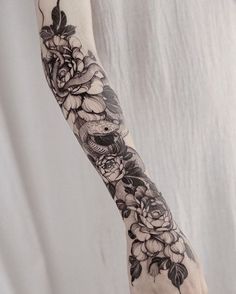 a woman's arm with black and white flowers on it