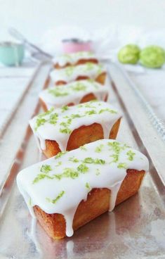 there are many small cakes that have icing on them and sprinkled with green