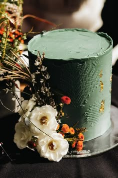 there is a green cake with flowers on the plate