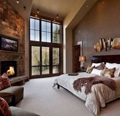 a bedroom with a large bed and fireplace in it