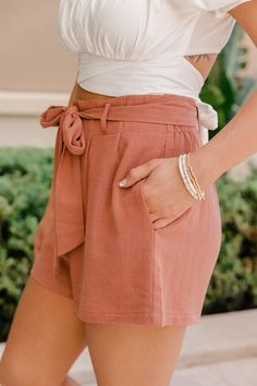 These sweet terracotta shorts are such an amazing choice for any summer afternoon! We love the trendy paperbag high waist fit - you can easily style it with any tops or bodysuits! The tie front and button detail make for a cute combination. Throw these on with a fabulous top and sandals for the perfect casual look! 85% Cotton, 15% linen Machine wash cold / Tumble dry low Unlined Materials may have natural variations Colors may vary from different viewing devices Trendy Solid Color Summer Shorts, Chic Paperbag Waist Shorts For Vacation, Chic Summer Shorts With Paperbag Waist, Summer Beach Shorts With Paperbag Waist, Trendy Paperbag Waist Bottoms For Summer, Trendy Summer Bottoms With Paperbag Waist, Trendy Summer Paperbag Waist Bottoms, Summer Paperbag Waist Shorts For Day Out, Trendy Brown Shorts For Day Out