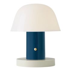 a blue and white table lamp with a white shade on the top, against a white background