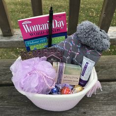 a basket filled with lots of different items on top of a wooden bench next to a book