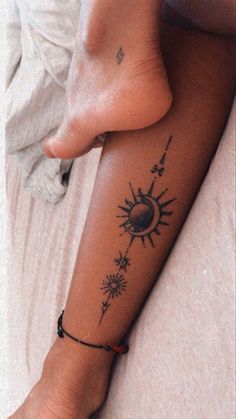 a woman's foot with a tattoo on it and the sun in the background