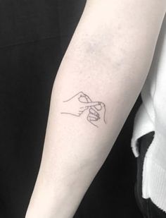 a woman with a tattoo on her arm holding the hand of another person's wrist