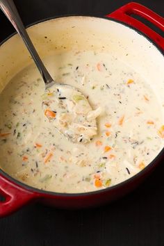 a red pot filled with soup on top of a stove