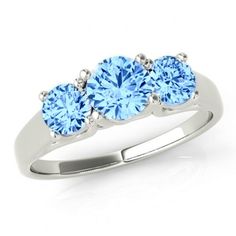 three stone blue topaz ring in white gold with diamonds on the sides and four round stones