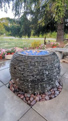 an outdoor fountain made out of rocks and stones in the middle of a patio area