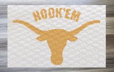 an embroidered texas longhorn logo is shown on a piece of white paper with the word nook'em written across it