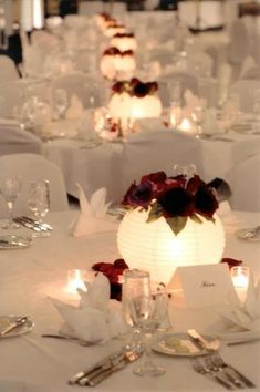 the tables are set with white linens and candles