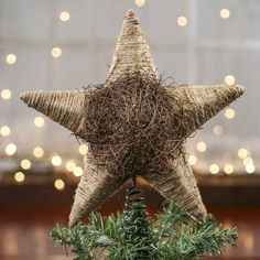 a star ornament is sitting on top of a christmas tree