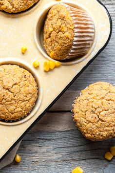 three muffins in a muffin tin with corn on the side