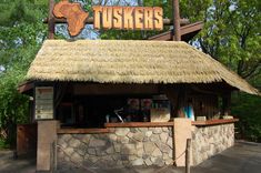 an outside kiosk with a sign that says tuskers on the roof