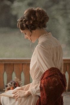 a woman sitting on a bench reading a book