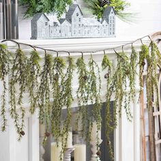 the mantle is decorated with greenery and candles