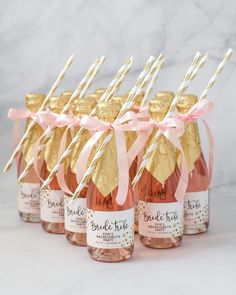 pink and gold champagne bottles with straws in them