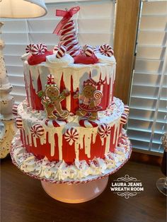 a three tiered cake decorated with candy canes and candies