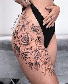 a woman's stomach with flowers on it and her hand holding the side of her thigh