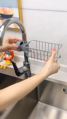 a woman is washing her hands under the faucet