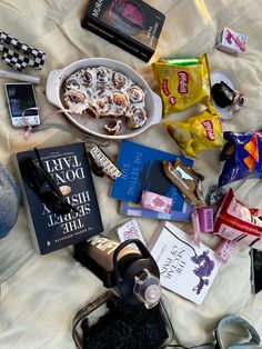 a table topped with lots of different types of food and drinks on top of a bed