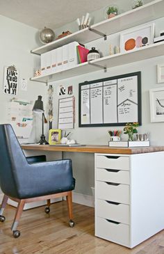 a desk with a chair and some pictures on the wall