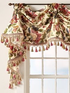 a window with a curtain and tassels hanging from it's valance