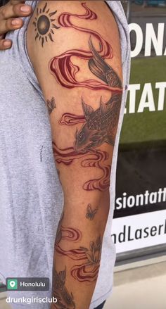 a man's arm with tattoos on it and an image of a fish in the water