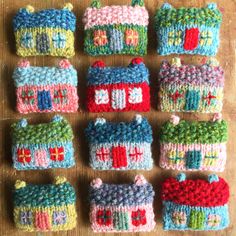 knitted houses are arranged in rows on a table