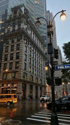 a city street with tall buildings in the background