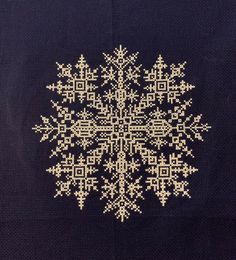 a cross - stitch snowflake is shown on a black background with white stitches