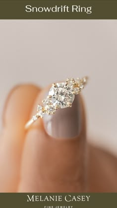 a person's hand with a ring on top of their finger and the words snowdrift ring above it