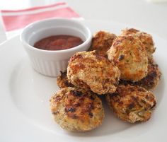 some crab cakes on a white plate with dipping sauce