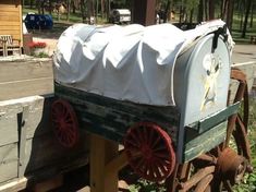 an old fashioned covered wagon sitting in the grass