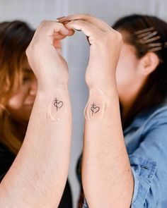 two people with tattoos on their arms