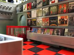 a room filled with lots of records and pictures on the wall next to a sink