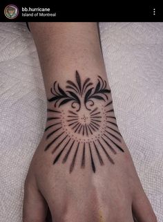 a person's hand with a sun tattoo on it