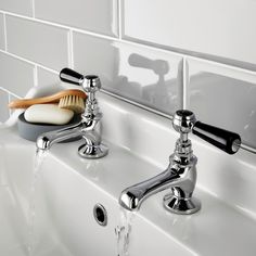 a bathroom sink with two faucets and soap dispenser