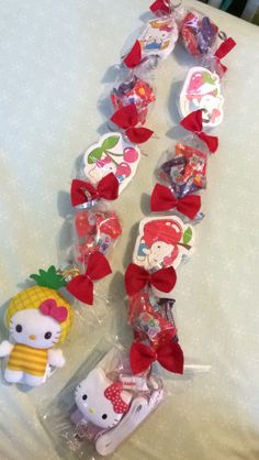 hello kitty and pineapple shaped candy candies in cello bags on a white tablecloth