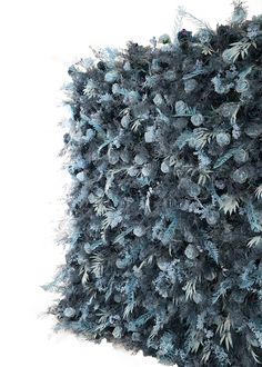 a blue and grey wall covered in pinecone trees with snow on the ground