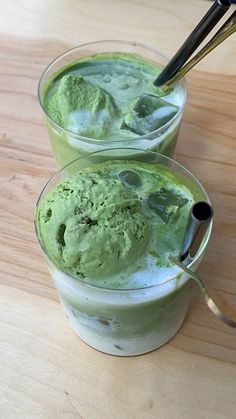 two glasses filled with ice cream on top of a wooden table