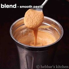 a spoon full of peanut butter being poured into a black cup with the words blend - smooth paste on it