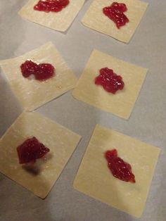 four square pieces of dough with jam on them