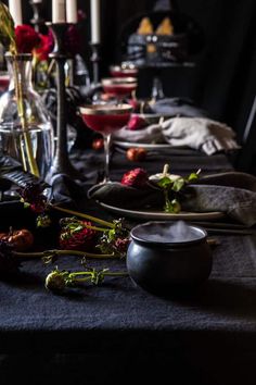 the table is set with candles, plates and other items for an elegant dinner party