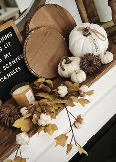 the mantle is decorated with white pumpkins and other autumn decorating items on it